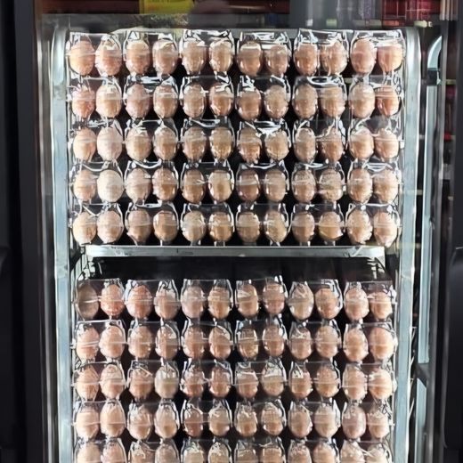 Refrigerated cooler stocked with cartons of jumbo eggs